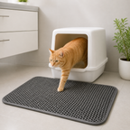 Gato mayor saliendo del arenero sobre alfombra doble capa atrapa arena